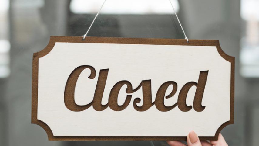 primer-plano-mano-mujer-sosteniendo-etiqueta-cerrada-puerta-vidrio_23-2148028045